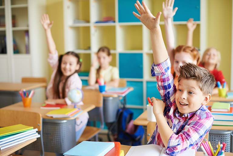 Kinder melden sich im Unterricht